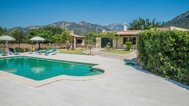 A swimming pool with lounge chairs, a pergola, and a mountain backdrop. - SINGLE FAMILY HOUSE ISOLATED WITH POOL, RURAL HOUSE IN A LAND OF 35. 000M2 (Selva- Cami Selva- Mallorca)