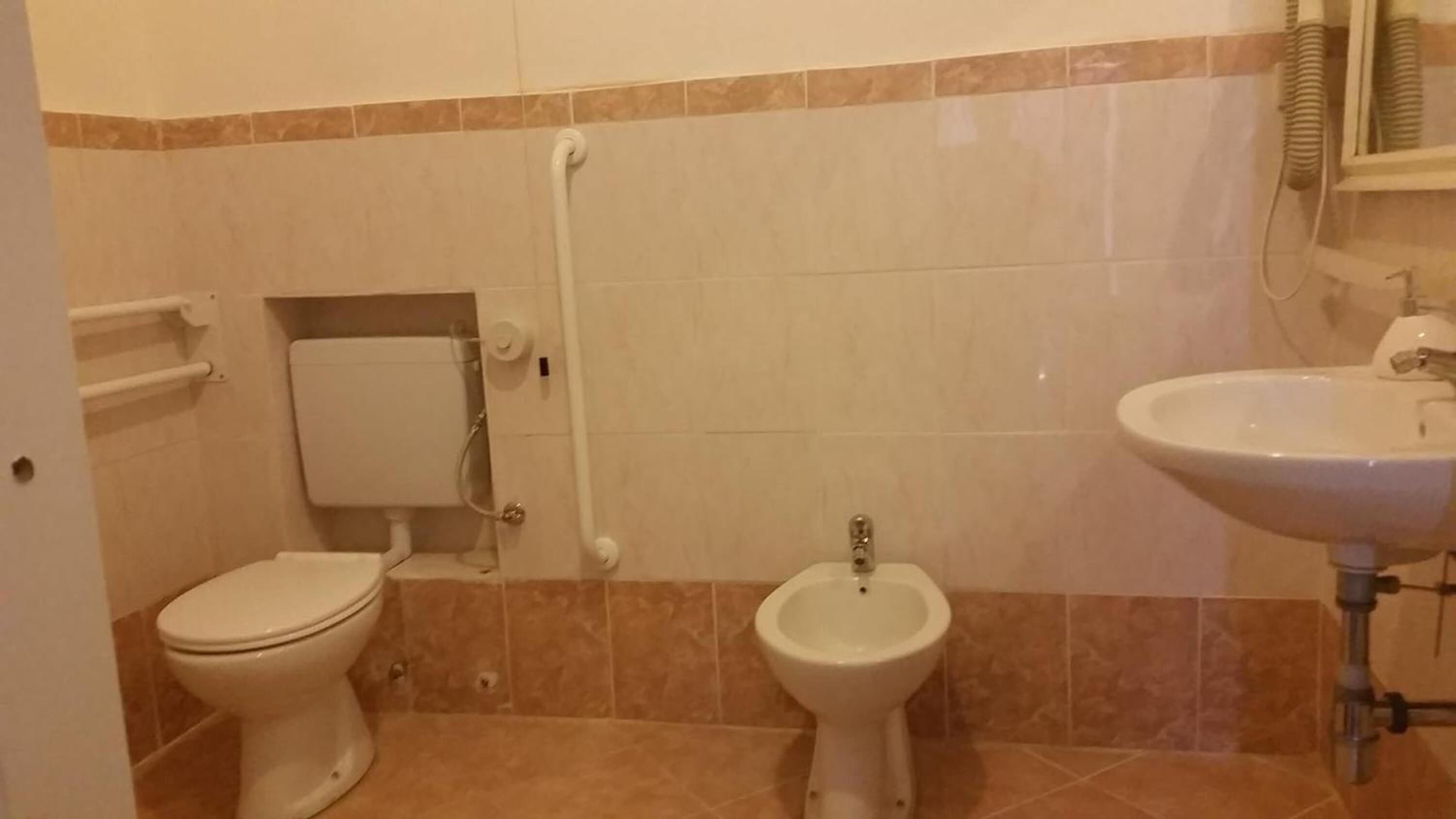 Un baño con inodoro, bidé y lavamanos.