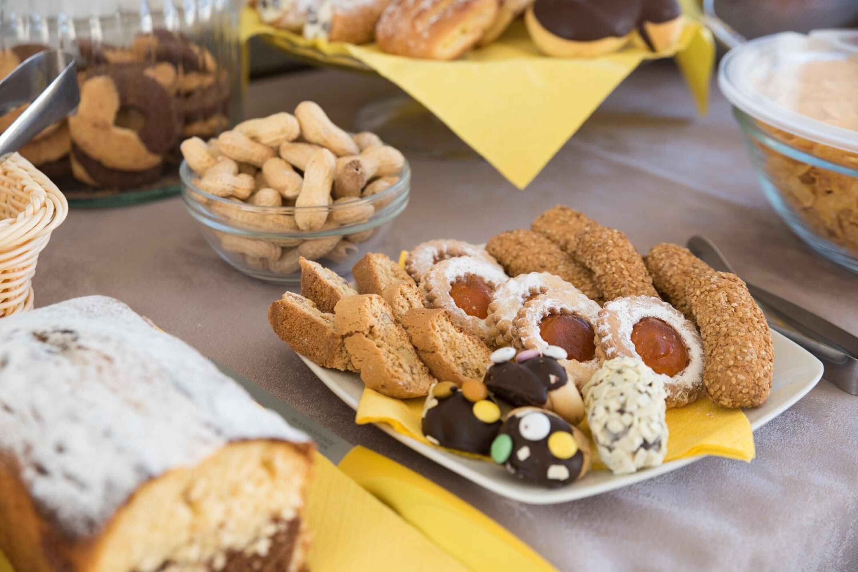 A table with various baked goods including cookies, pastries, and bread.