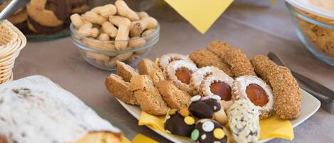 A table with various baked goods including cookies, pastries, and bread.