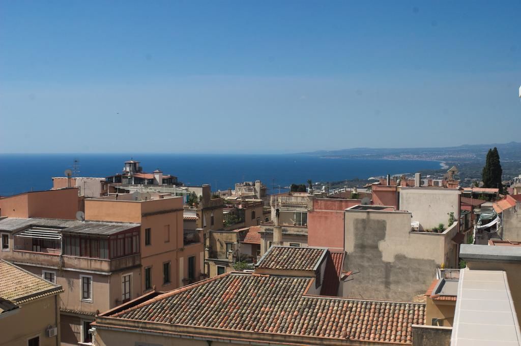Paisatge marítim urbà amb edificis de teules terracota i vista al mar.