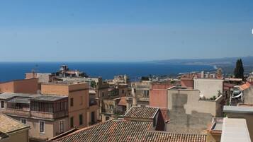 Paisatge marítim urbà amb edificis de teules terracota i vista al mar.