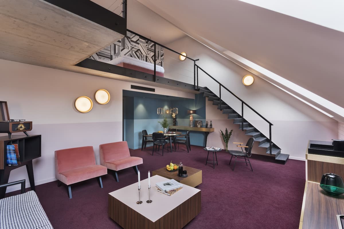 Un espace de vie moderne de style « loft », comprenant un escalier, un coin salon et une cuisine.