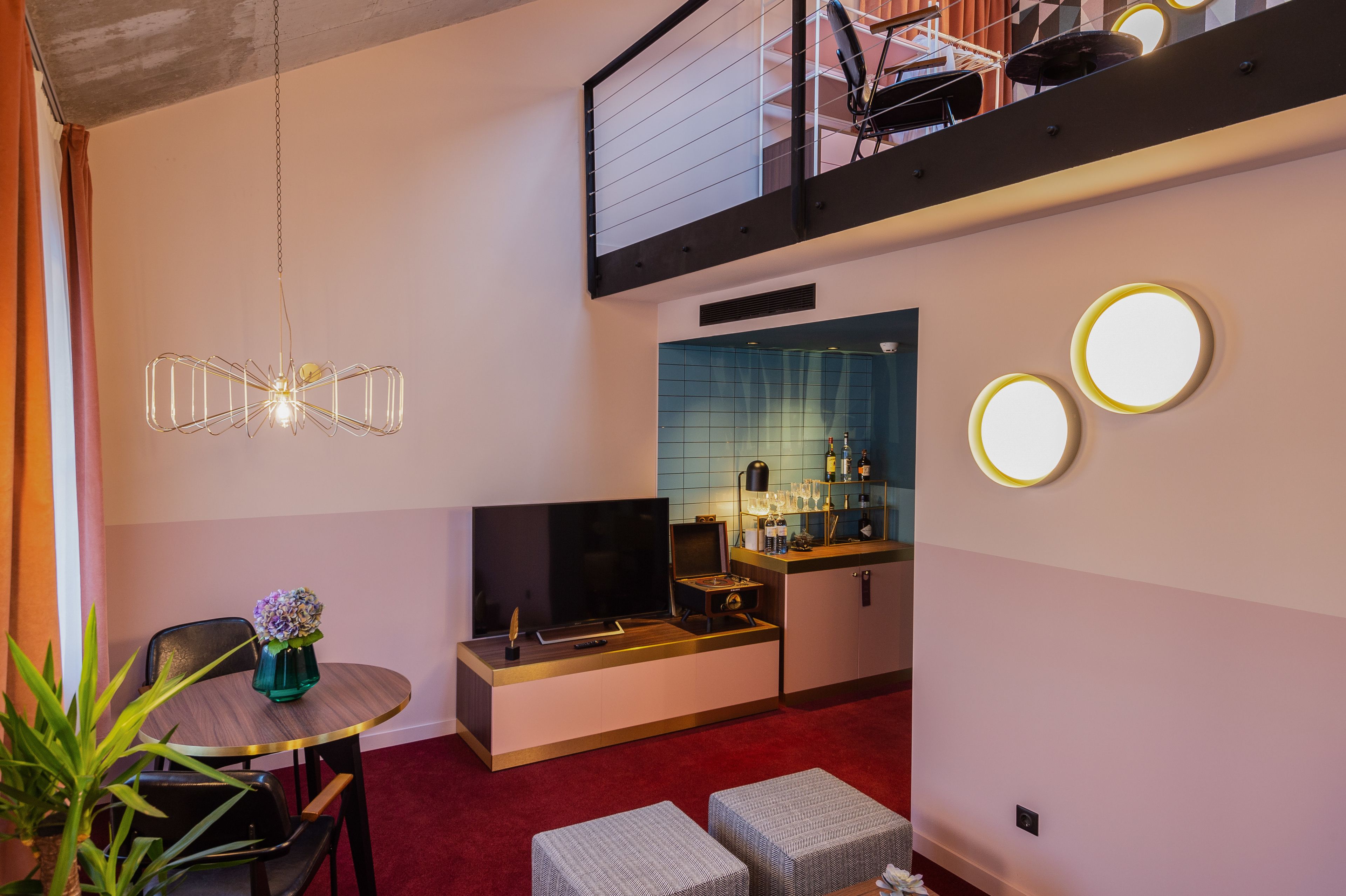 Un espace de vie compact comprenant un téléviseur, un coin cuisine et un espace repas avec une table et des chaises.