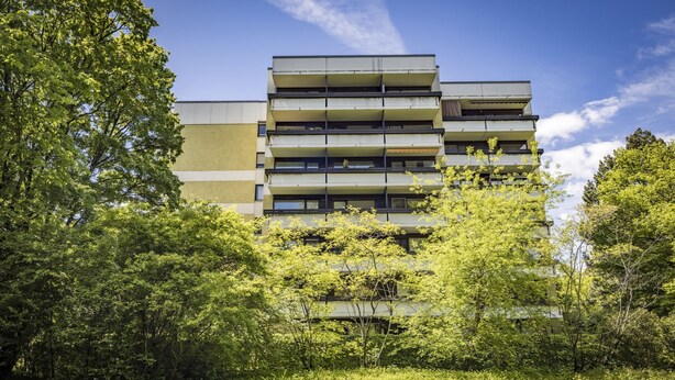 A multi-story building with a flat roof and balconies, surrounded by lush greenery. - Ferienwohnung Wittelsbacherstr. 10 -  in ruhiger und zentraler Lage (Bad Reichenhall)