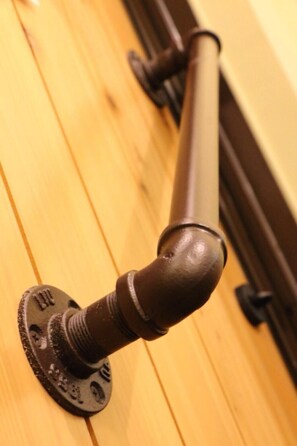 A close-up of a door handle with a round knob, mounted on a wooden door.
