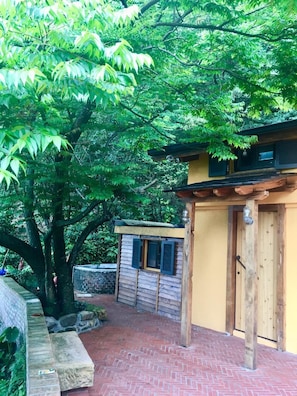 A rustic wooden building with a brick pathway leading to a wooden door.