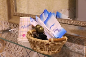 A wicker basket containing toiletries and a paper cup with a floral design.