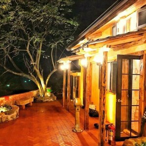 A wooden building with a porch, a bench, and a tree. - Luck Homestay (New Taipei City)