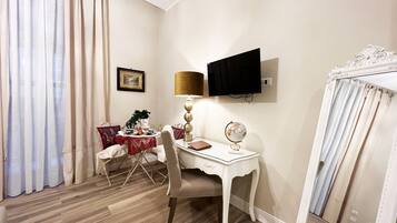 Deluxe Room | Living area | 54-inch plasma TV with cable channels