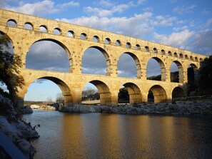 Un aqueduc en pierre, doté de plusieurs arches, enjambe une rivière.