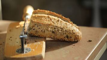 Een meergranenbrood dat op een houten snijplank wordt gesneden.
