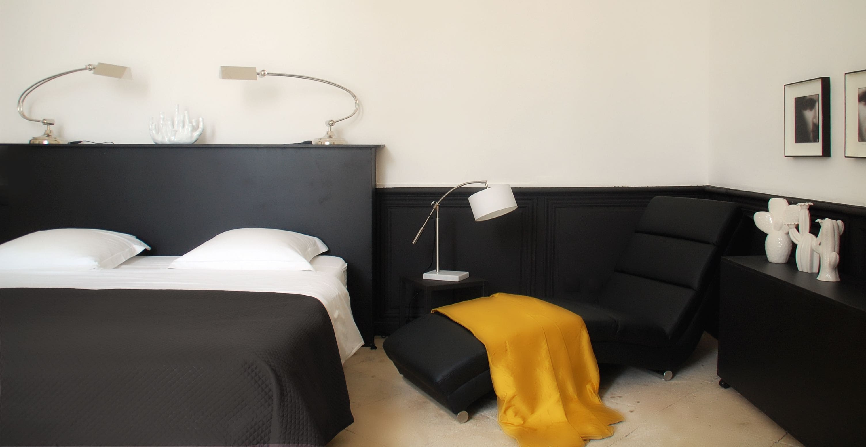 Ein Hotelzimmer mit einem Bett, einem Sessel, einem Nachttisch und einem kleinen Tisch mit Dekoration.