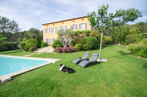 A house with a swimming pool, a dog, and two lounge chairs. - Bastide Tara (Cabries)