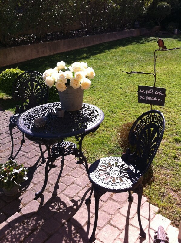 A garden table with a potted plant and a chair. - Bastide Tara (Cabries)