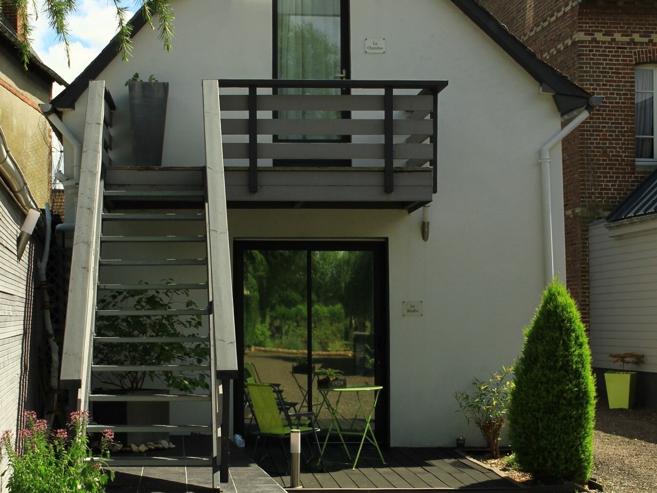 Una casa moderna con una escalera de madera que da a un balcón.