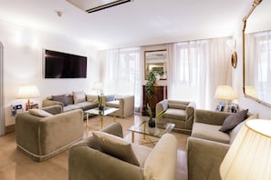 A modern living room with a sofa set, a glass coffee table, and two lamps. - Hotel Cecil (Rome)
