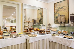 A buffet with a variety of food items and a large mirror reflecting the room. - Hotel Cecil (Rome)