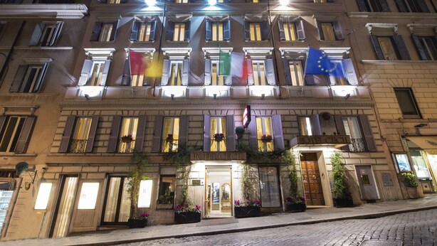 Eine historische Hotelansicht mit mehreren Balkonen, großen Fenstern und einem markanten Eingang.