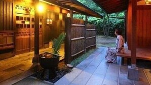 A covered outdoor area with a wooden structure, a seating bench, and a small fire pit. - Hirayama Onsen Yama Futokoro no Yado Ichiboku Isso (Yamaga)