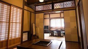 A traditional Japanese room with tatami flooring, a low table, and sliding doors. - Hirayama Onsen Yama Futokoro no Yado Ichiboku Isso (Yamaga)