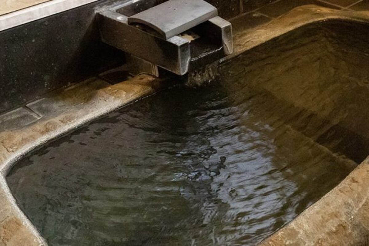 A stone bathtub with water flowing into it.