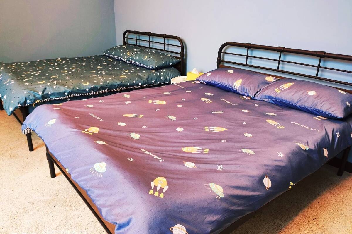 Una habitación con dos camas individuales, cada una con un edredón de estampado diferente.