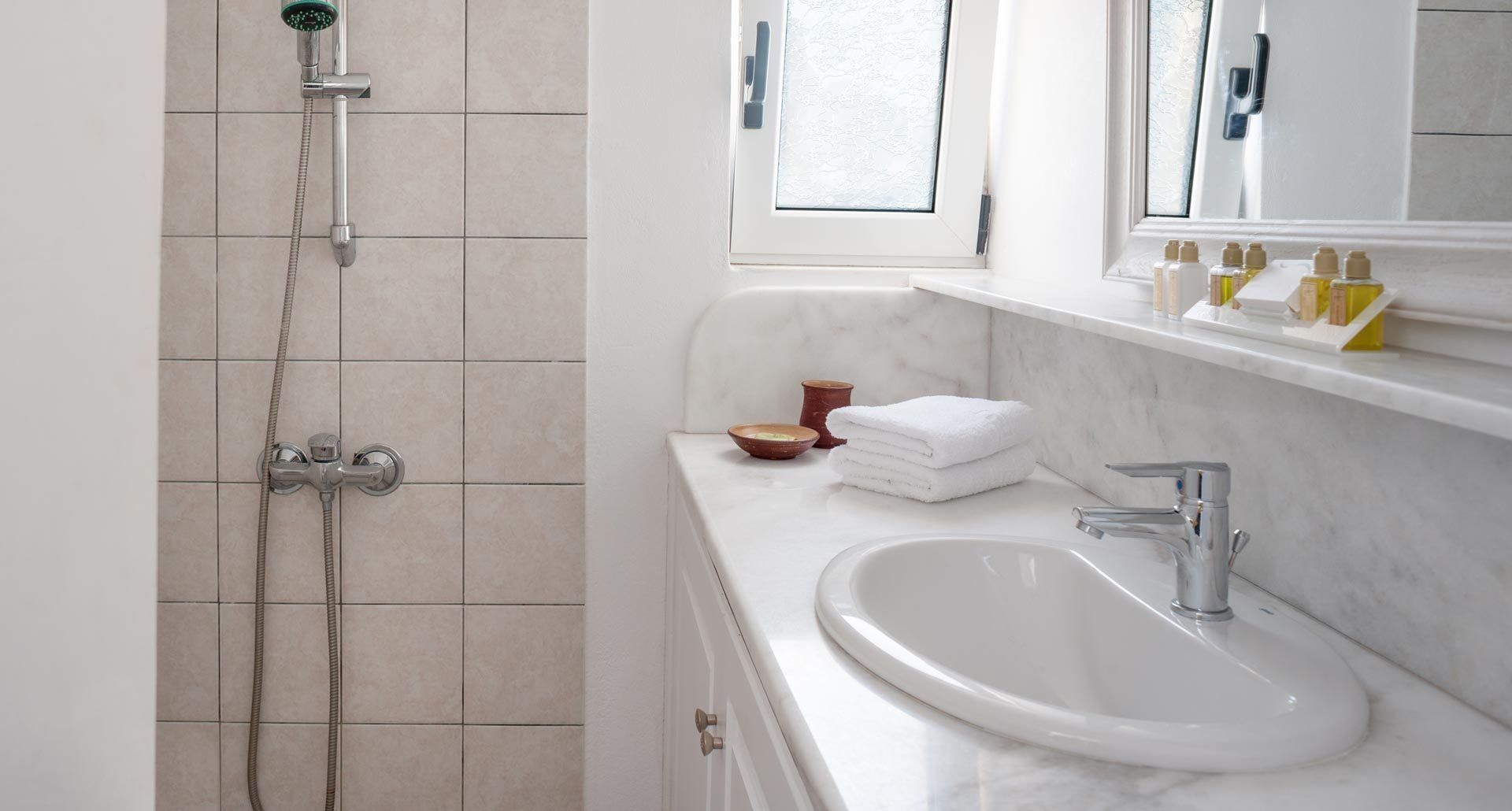 A bathroom with a shower, a sink, and a mirror.