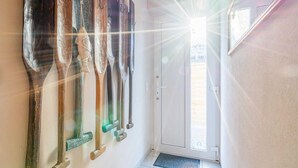 Ein Flur mit Wandbildern aus Holz und einer Tür, die auf einen Balkon führt.