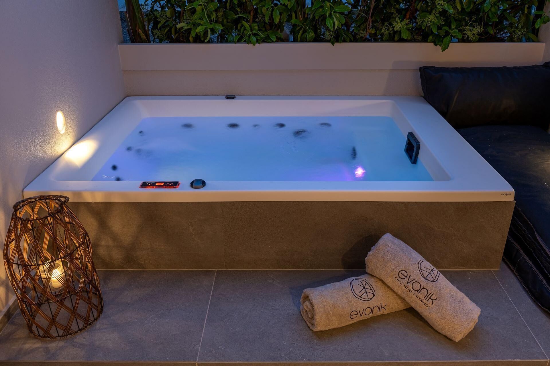Una bañera de hidromasaje rectangular con un panel de control y un pequeño dispositivo en el borde.