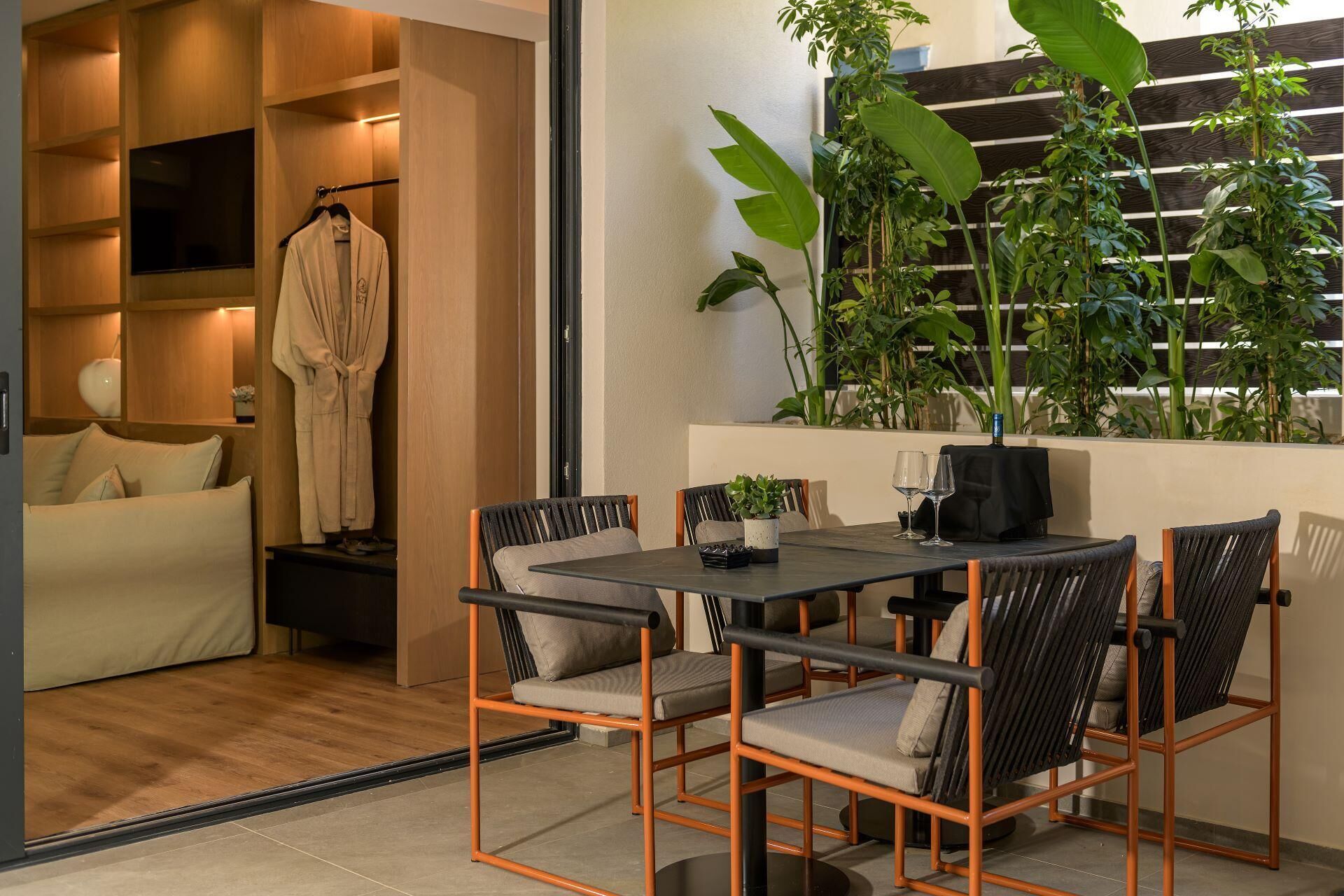 Una sala de estar moderna con un sofá, una mesa de comedor con sillas, un televisor y una planta en maceta.
