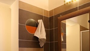 A bathroom with a large mirror, a sink, and a toilet. - Le 3 B (Catania)