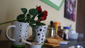 A kitchen counter with two mugs, a rose, a honey dipper, and some bread. - Le 3 B (Catania)
