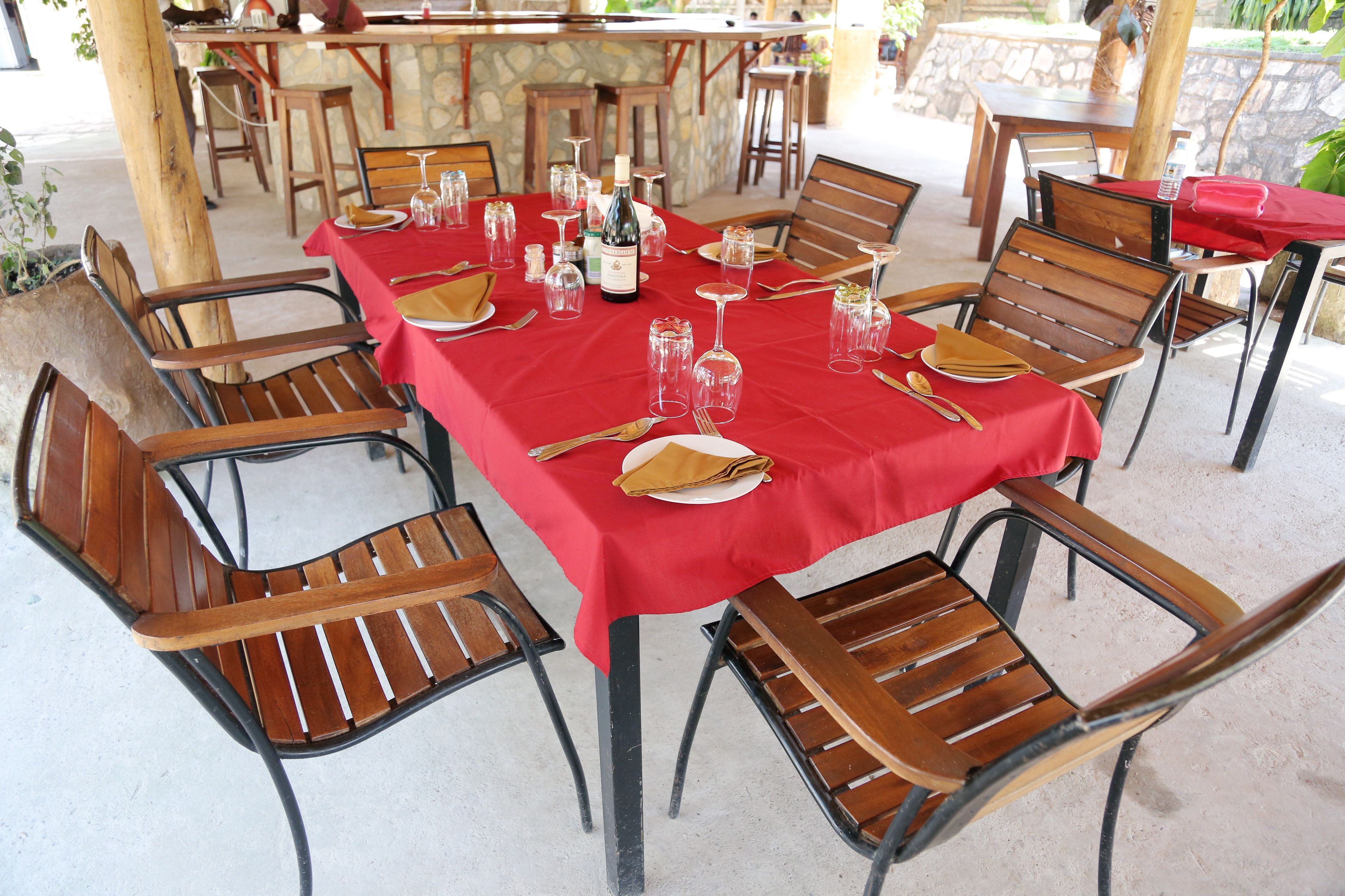 A table set for dining with chairs, a bottle of wine, and glasses.