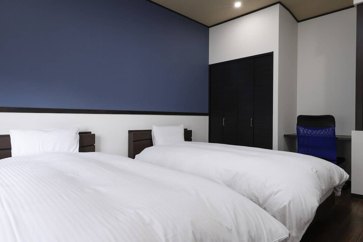 Ein Hotelzimmer mit einem großen Bett, einem Kleiderschrank und einem Schreibtisch.