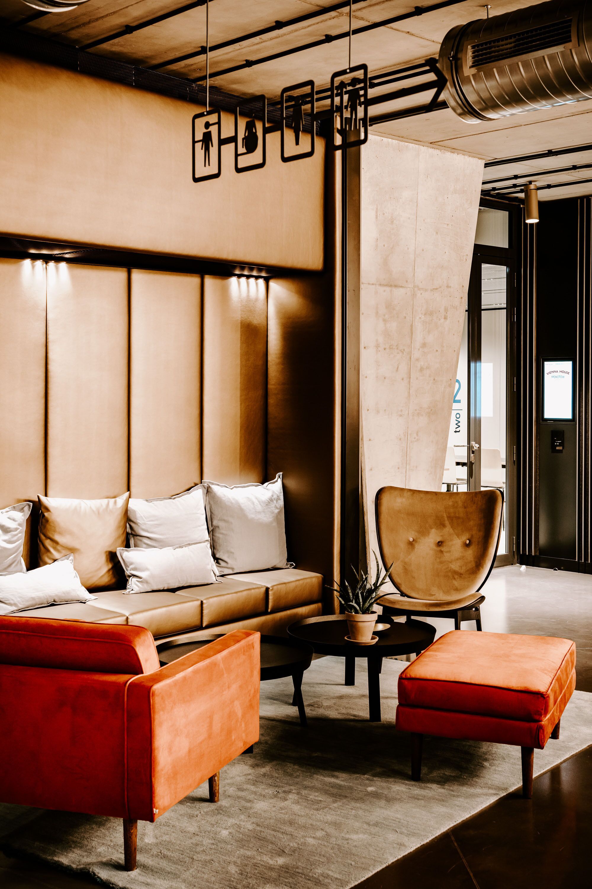 A modern lobby with a leather sofa, a red armchair, and a coffee table.