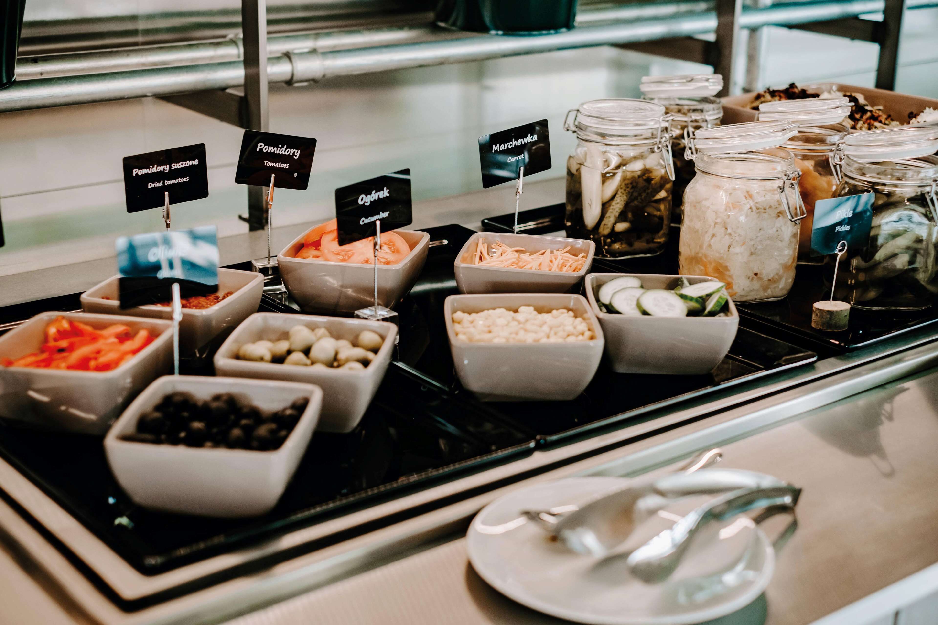 A buffet with various food options including dried fruits, tomatoes, and pickles.