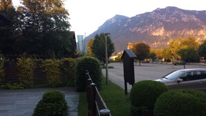 A residential area with a mountain in the background, a street with parked cars, and a mailbox. - Appartements Reiter am See (Inzell)