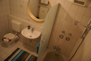 Une salle de bain comprenant des toilettes, un lavabo, une baignoire et une douche.