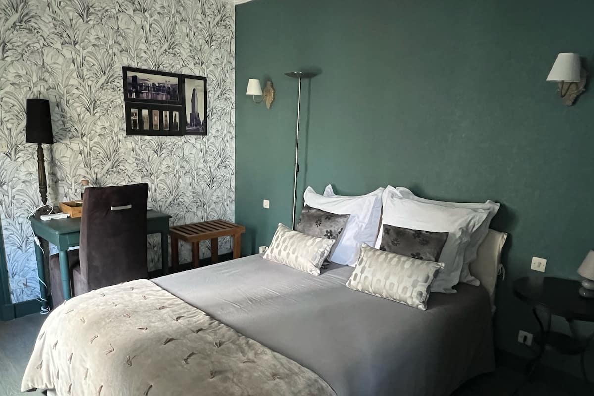 Un dormitorio ordenado con una cama, un escritorio y una silla.