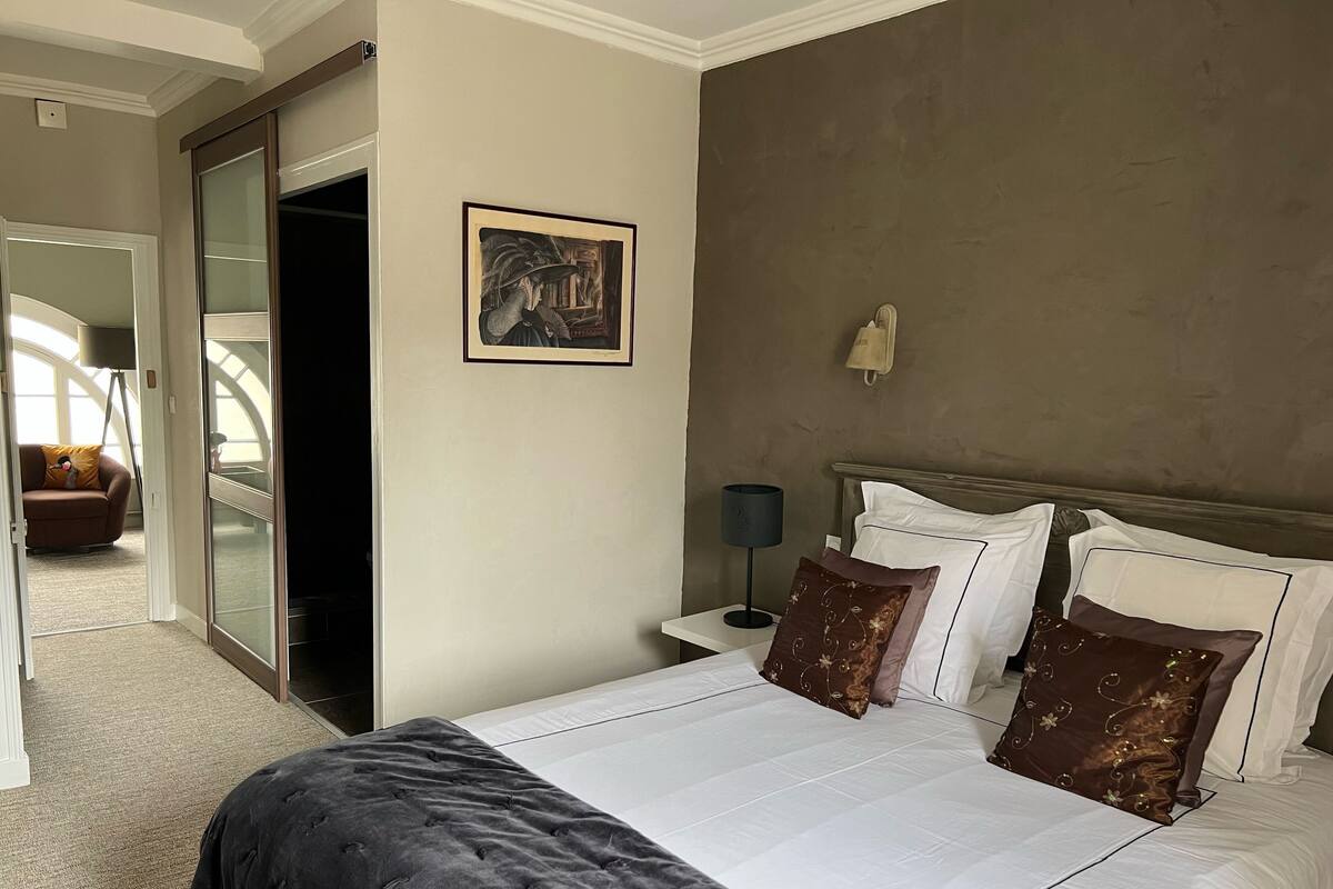 Habitación de hotel con una cama grande, una mesita de noche, una lámpara y un cuadro en la pared.