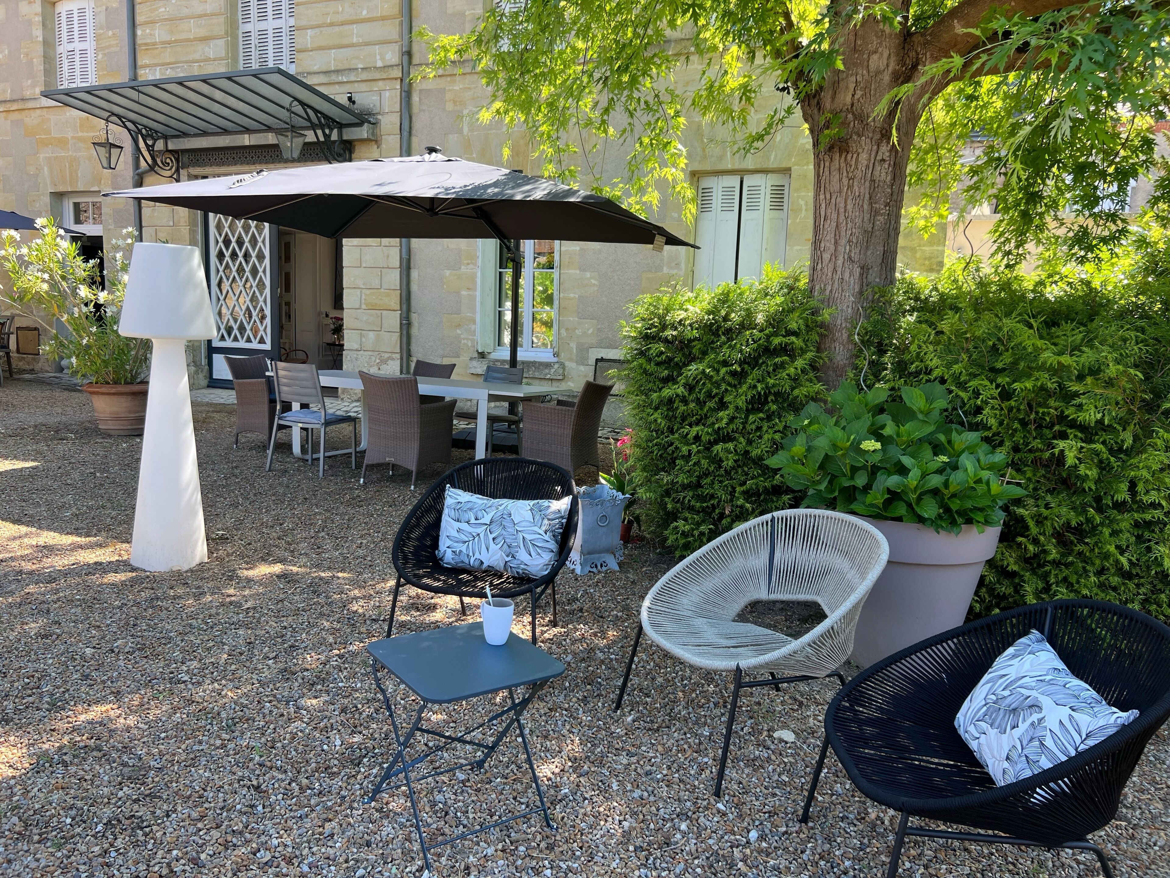 An outdoor seating area with wicker chairs, a table, and a large umbrella.
