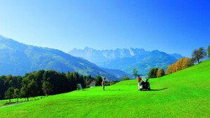 A golf course with a clear view of mountains in the background. - Ferienwohnung Kaiserstüberl (Reit im Winkl)