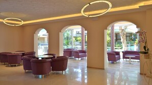 A spacious lobby with modern furniture, large arched windows, and decorative lighting fixtures. - Hotel Castellucci (Bellaria-Igea Marina)