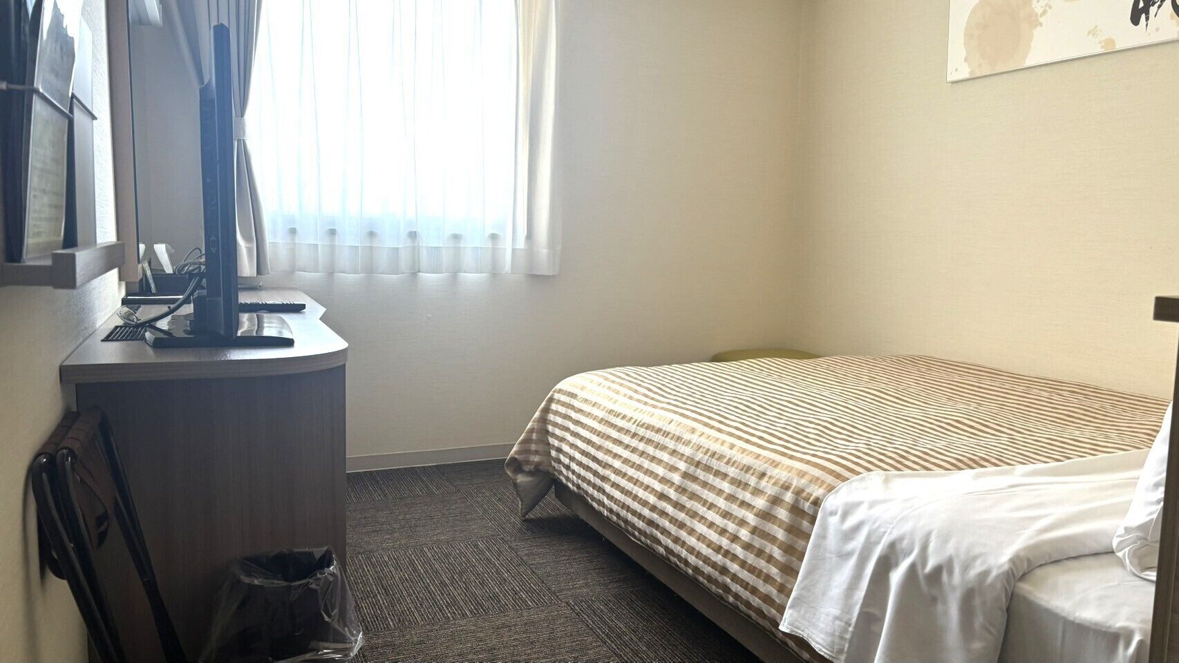 Una habitación de hotel con una cama, un escritorio y una silla.