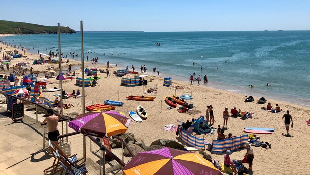 A crowded beach with umbrellas, beach chairs, and people enjoying the water. - Tresowes Green Cottage (Helston)