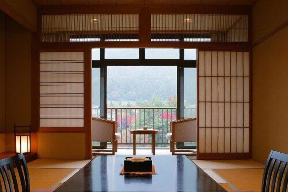 A traditional Japanese room with tatami flooring, a low table, and sliding doors.