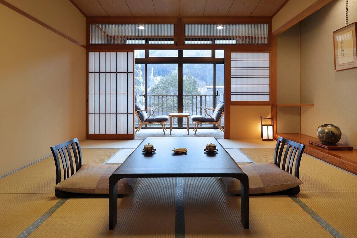 A traditional Japanese room with tatami flooring, a low table, and shoji screens.