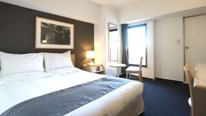 A hotel room with a bed, a bedside table with a lamp, a chair, a small table, and a window with curtains. - HOTEL THE CENTRE UTSUNOMIYA (Utsunomiya)
