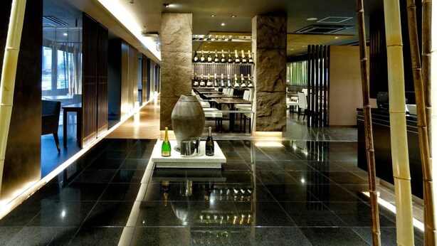 A spacious lobby with a polished floor, a central decorative vase, and a bar area with bottles. - HOTEL THE CENTRE UTSUNOMIYA (Utsunomiya)
